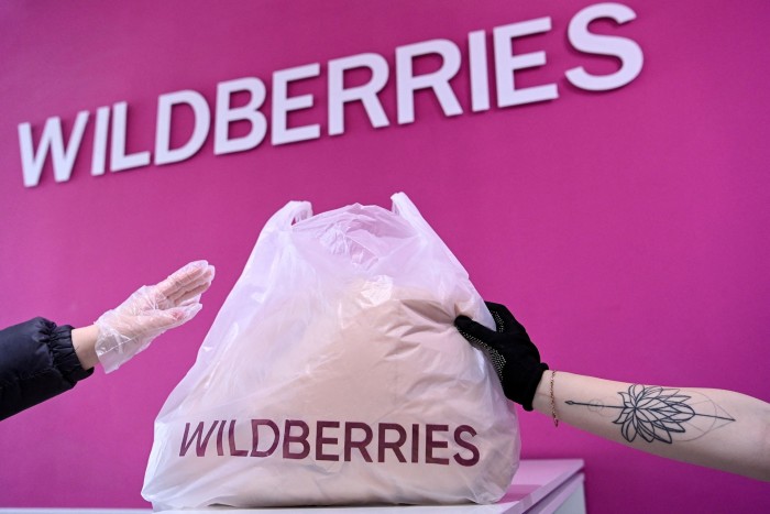 A woman receives her order at a pick-up point of Russia’s ecommerce group Wildberries in Moscow, Russia