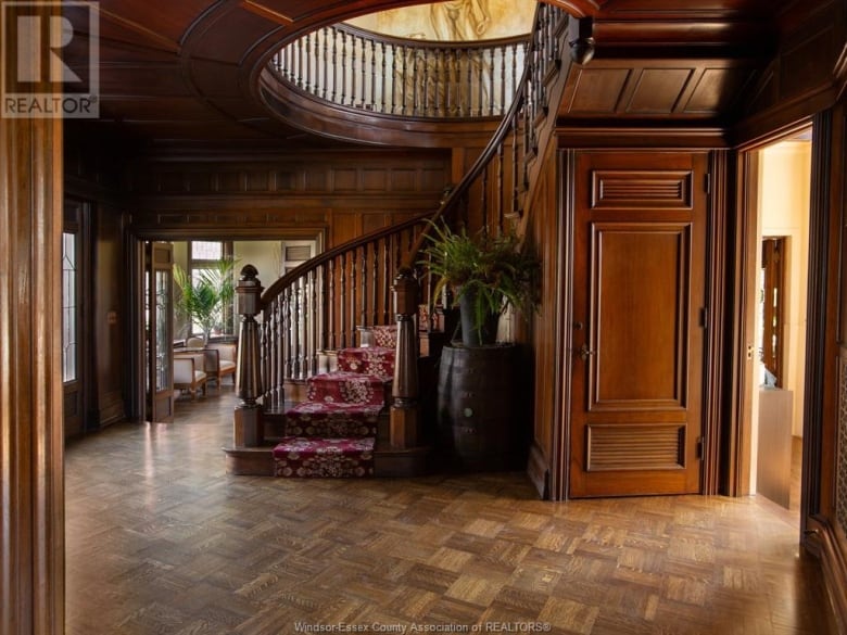 A staircase in a room covered in wood paneling.