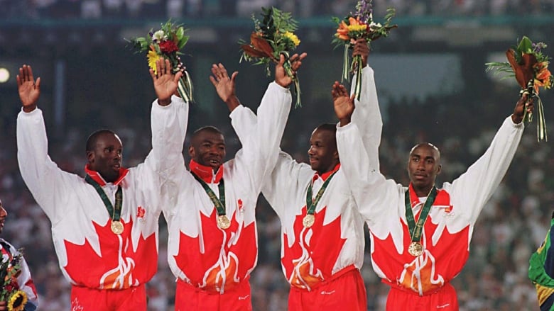 Bruny Surin, Glenroy Gilbert, Donovan Bailey and Robert Esmie, left to right, wave from the podium after winning Olympic gold medal for the men's 4x100 metre relay at the Summer Olympic Games Saturday in Atlanta.