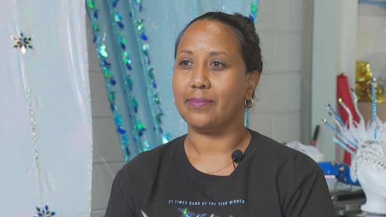 A woman looks off into the distance as she's being interviewed. 