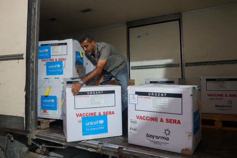 A man unloads boxes from the back of a truck. The boxes are marked 'URGENT' and 'VACCINE & SERA.' They are branded "Unicef" and "bioparma."