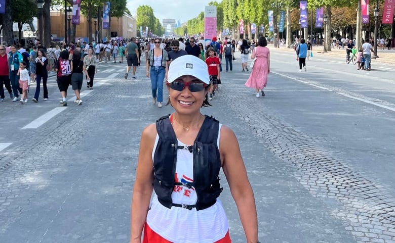 A woman in running gear stands in a busy road