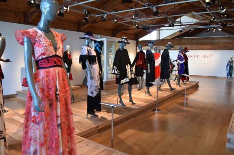 Mannequins standing in a line with seven floor and knee length dresses.  