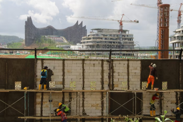 Workers build a wall at the future presidential palace in Nusantara, Indonesia