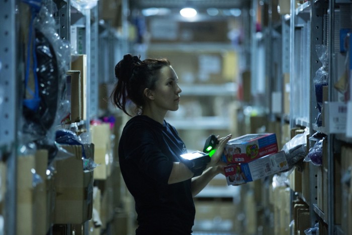 ​A worker scans goods as she collects products from a storage bay in the distribution centre operated by online retailer Wildberries, in Podolsk, Russia