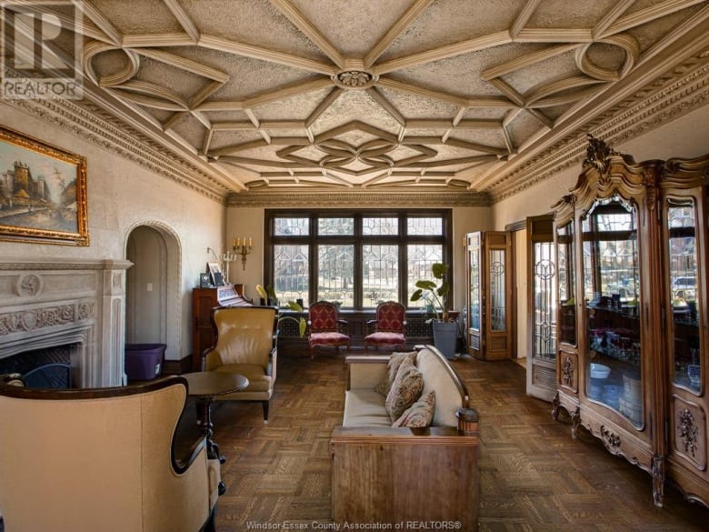 An ornate room with a sofa and chairs.