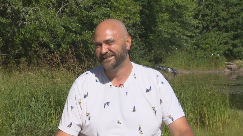 A smiling man in white t-shirt