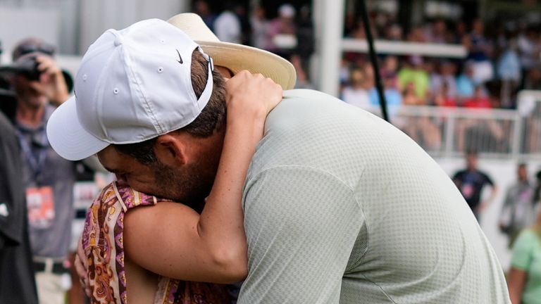 Scottie Scheffler holds his wife Meredith Scudder on the 18th green after he won the final round of the Tour Championship golf tournament, Sunday, Sept. 1, 2024, in Atlanta. (AP Photo/Mike Stewart) 