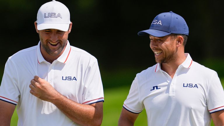 Scottie Scheffler, left, and Xander Schauffele, both of the United States, laugh on the 13th green during a practice round for the men's golf event at the 2024 Summer Olympics, Wednesday, July 31, 2024, at Le Golf National in Saint-Quentin-en-Yvelines, France. (AP Photo/George Walker IV)