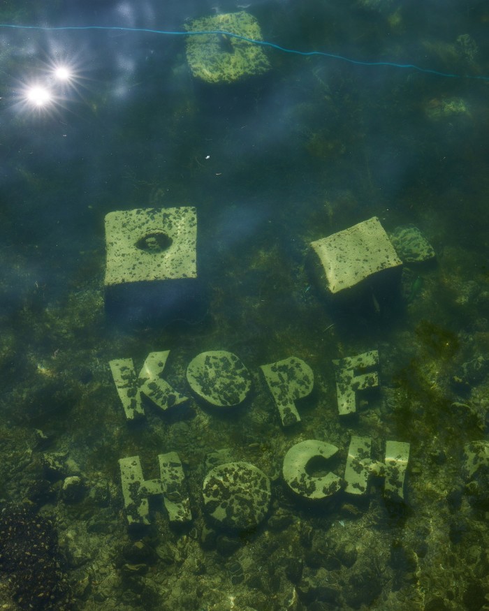 Stone capital letters spelling out ‘Kopf Hoch’ 