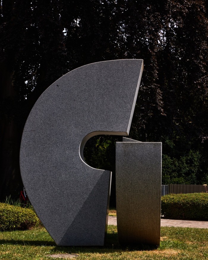 Ödön Koch’s ‘Sculpture in Two Elements’: a stone semicircle standing on its side beside a stone plith