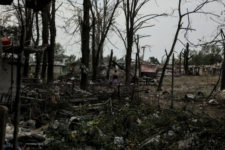 A local resident walks near residential buildings heavily damaged during a Russian military attack.