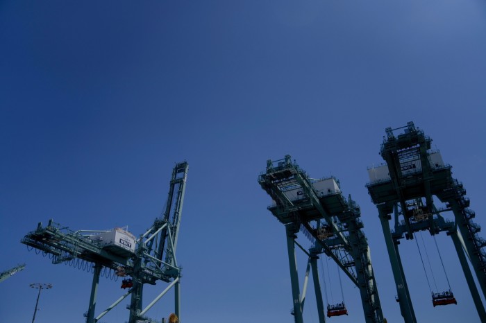 Three large cargo cranes tower over the Port of Los Angeles 