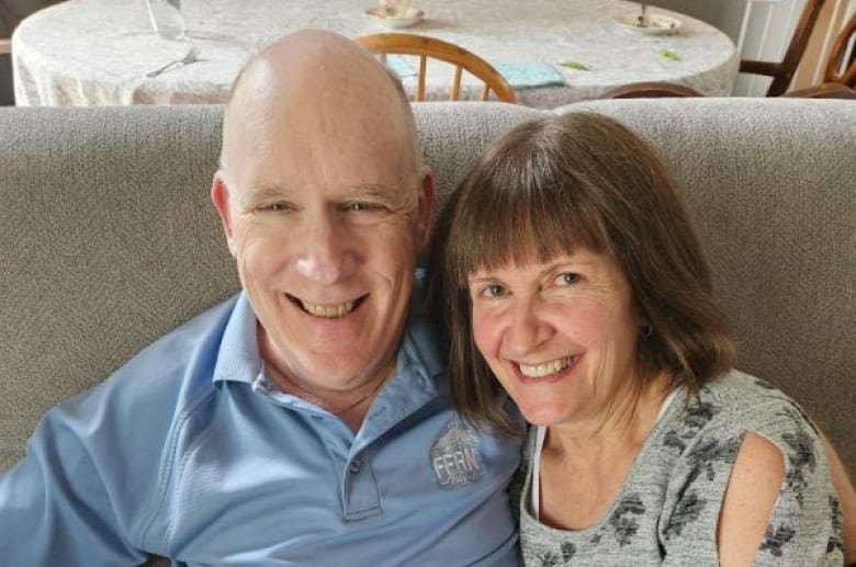 A man and woman  pose on  a couch