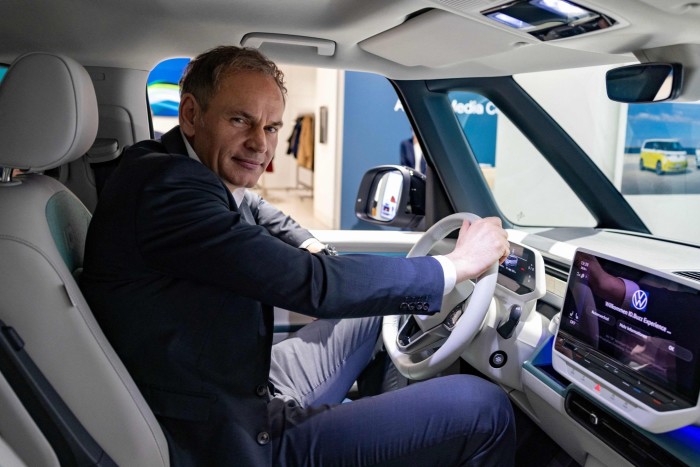 Oliver Blume sits at the wheel of a Volkswagen ID Buzz van.