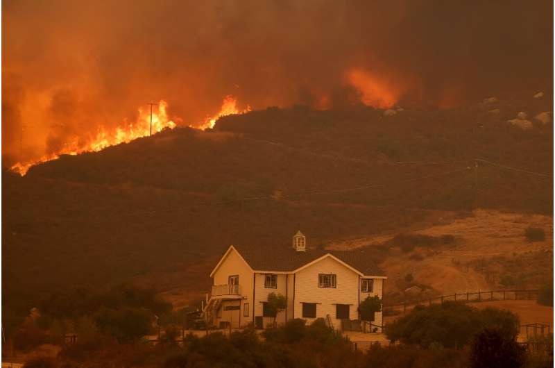 A house is threatened as the Airport Fire gains ground near Lake Elsinore