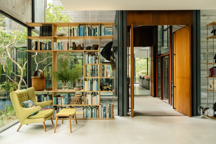 An open-plan room, with open shelving behind a modern chair