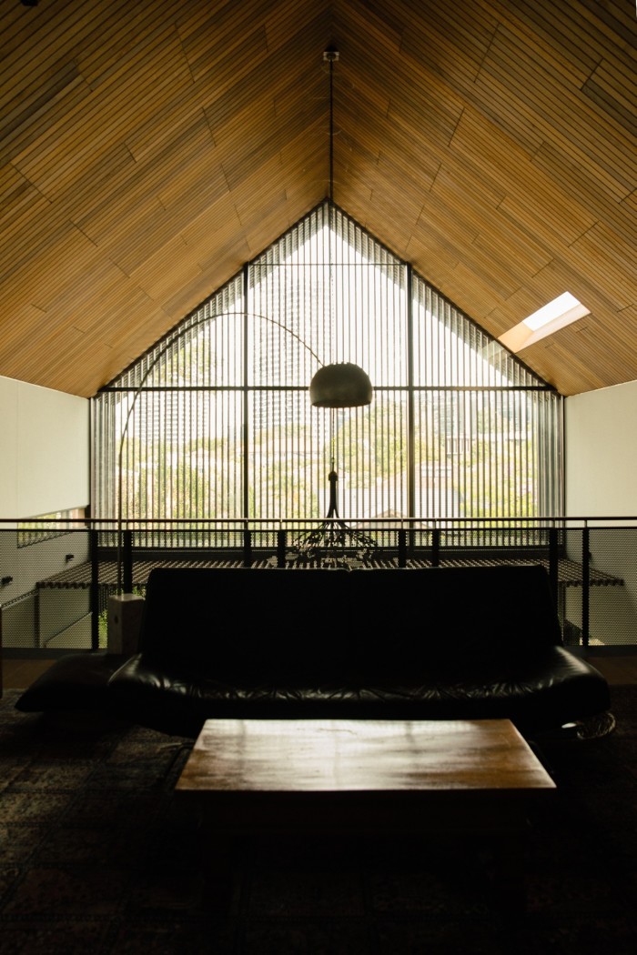 A large window casts light on a dark wood table