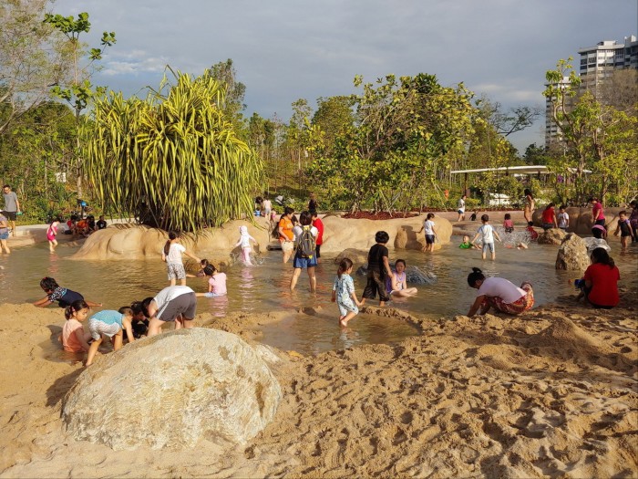 Children play in water and sand in a park