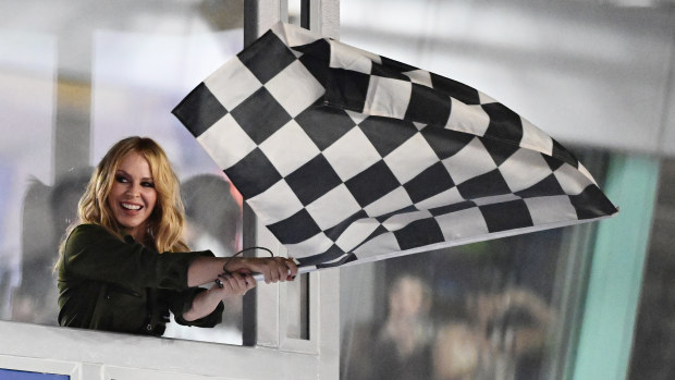 Kylie Minoque waves the chequered flag during the F1 Grand Prix of Singapore at Marina Bay Street Circuit on September 22, 2024 in Singapore, Singapore. (Photo by Pauline Ballet - Formula 1/Formula 1 via Getty Images)