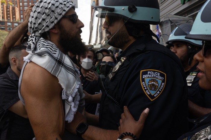 A pro-Palestinian demonstrator and a New York City police officer confront one another