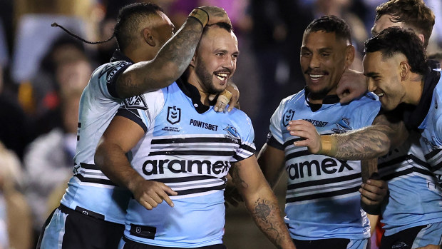 Braydon Trindall of the Sharks celebrates with teammates after scoring a try.