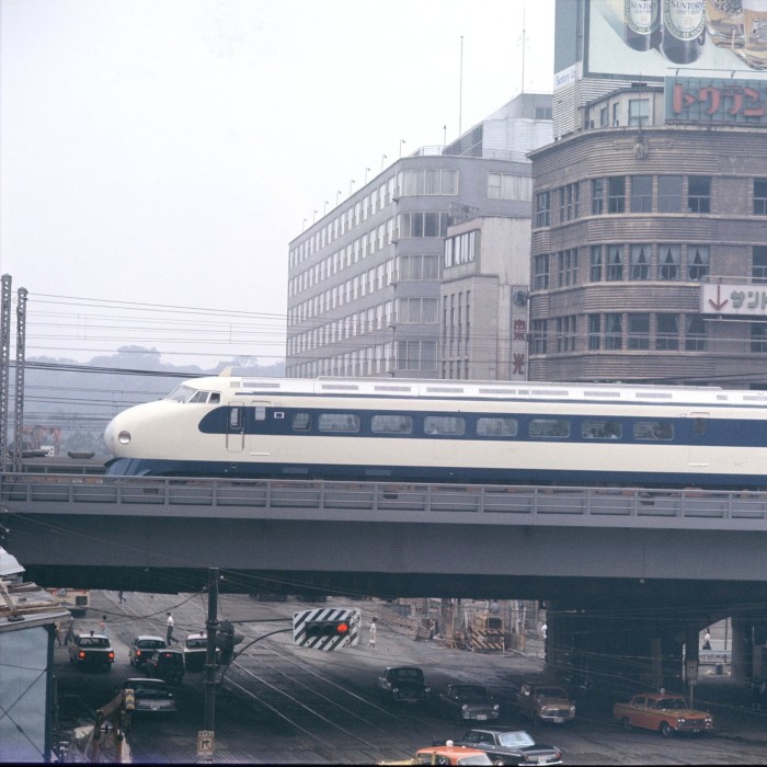 A train speeds along a viaduct above a city street