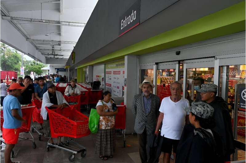 People queue up outside a supermarket in hurricane-hit Acapulco