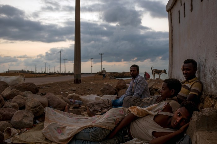 Bedding down on sheets of cardboard and sacks, a group of exhausted tahrib wake up on the roadside close to Obock’s port