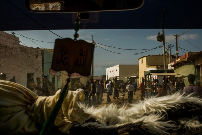 A narrow view of Obock’s dusty main street is seen through a partially blacked-out windscreen of a smuggler’s pick-up truck