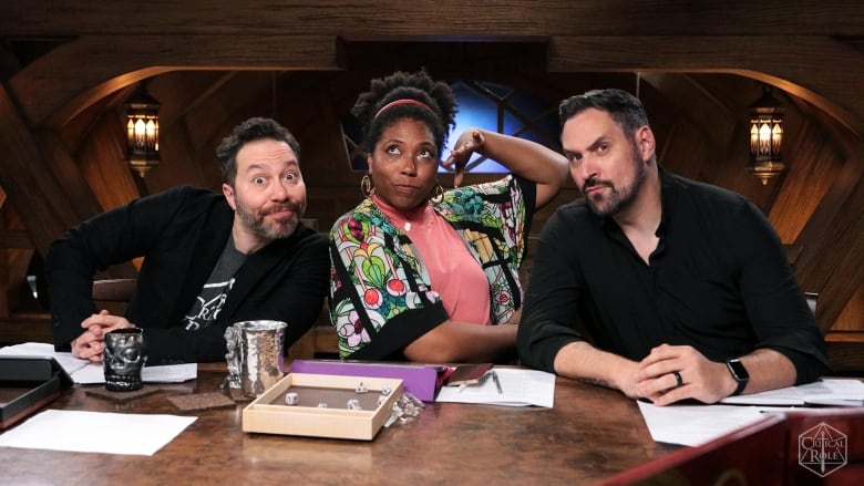 Three people sit at a table together. 