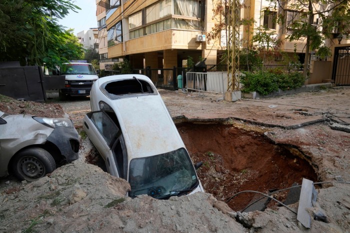 A car sits in a crater in Beirut’s southern suburbs, Saturday, Sept. 28, 2024. 