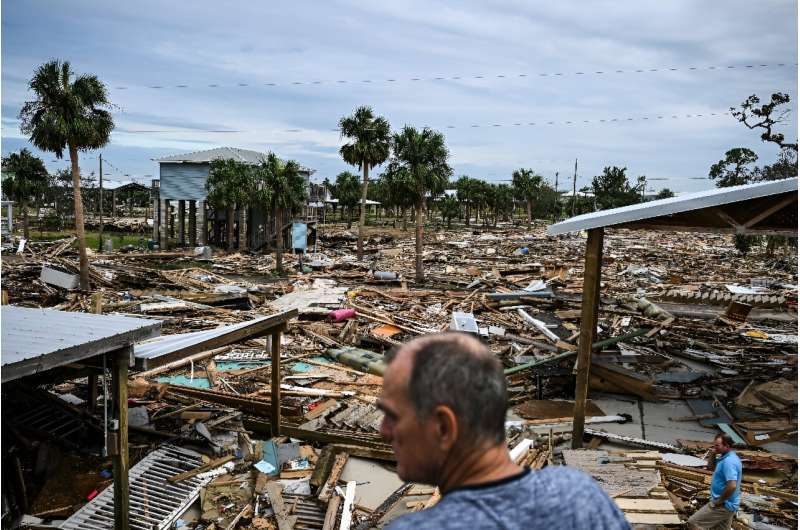 David Hester (L) and Bo Hester inspect the damage wrought by Hurricane Helene in Horseshoe Beach, Florida