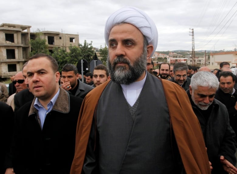 A group of men walk in the street.