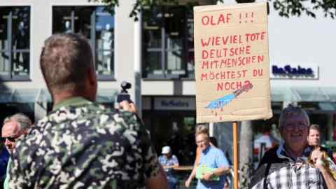 A protester in Jena holds a placard saying ‘Olaf! How many more dead Germans do you want to see?’