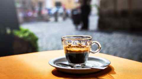 Cup of hot black coffee espresso on table in street cafe, Rome