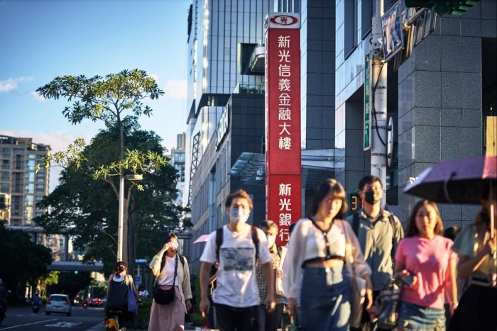 People walk past a branch of Shin Kong bank in Taipei