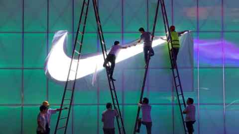 A Nike logo lamp being installed outside  a Beijing arena