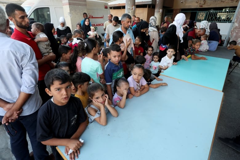 Kids crowd a blue table in a hospital