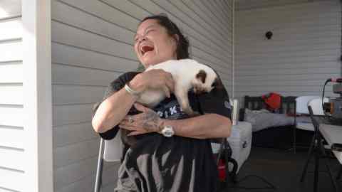 Diane Cruz cuddles a cat in her backyard in Springfield