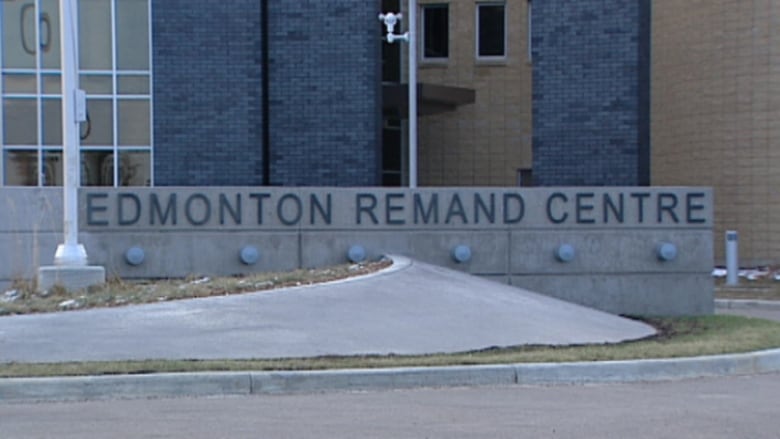 A view of a brick building with a concrete sign in front that says "Edmonton Remand Centre"