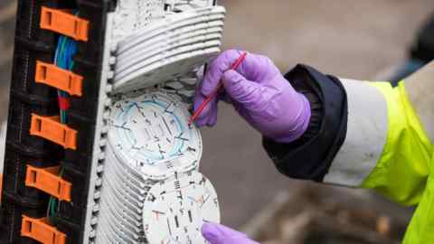 An Openreach engineer attaching fibre optics to a control unit