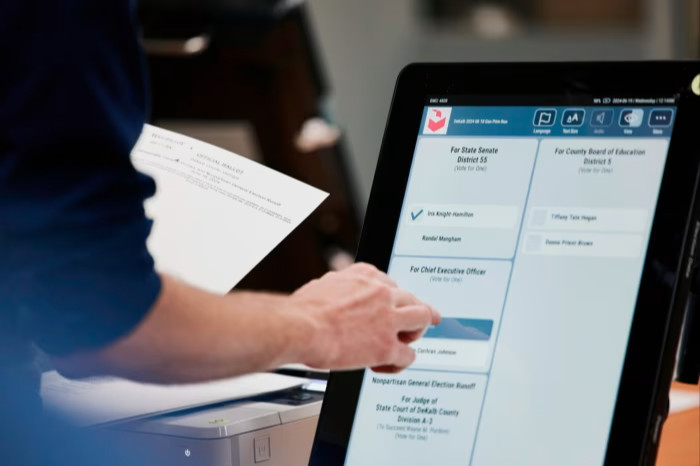 An official taps a screen to conduct an election security health check