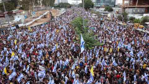 Thousands of protesters lift flags and placards during an anti-government rally