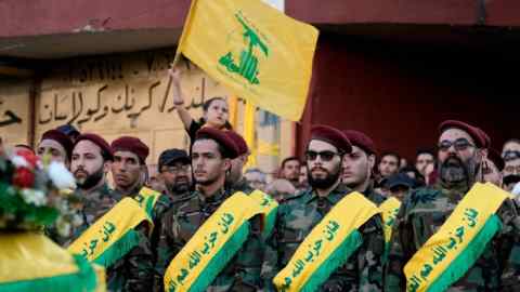 Hizbollah members attend the funeral procession of their comrades who were killed in Israeli strikes