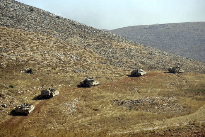 Tanks drive along a track during the 2006 war