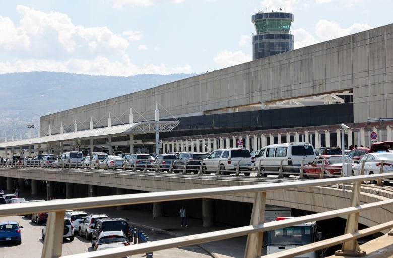 Cars line up outside an airport.