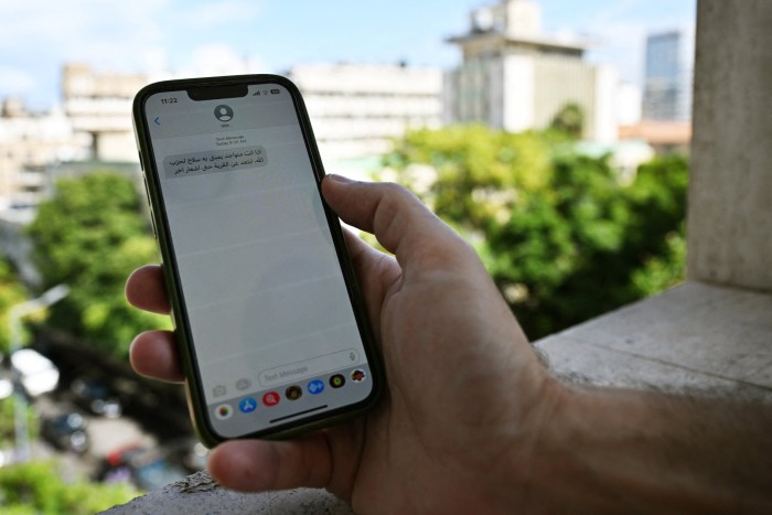 A Lebanese man in Beirut shows the warning he received by text message from Israel on Monday