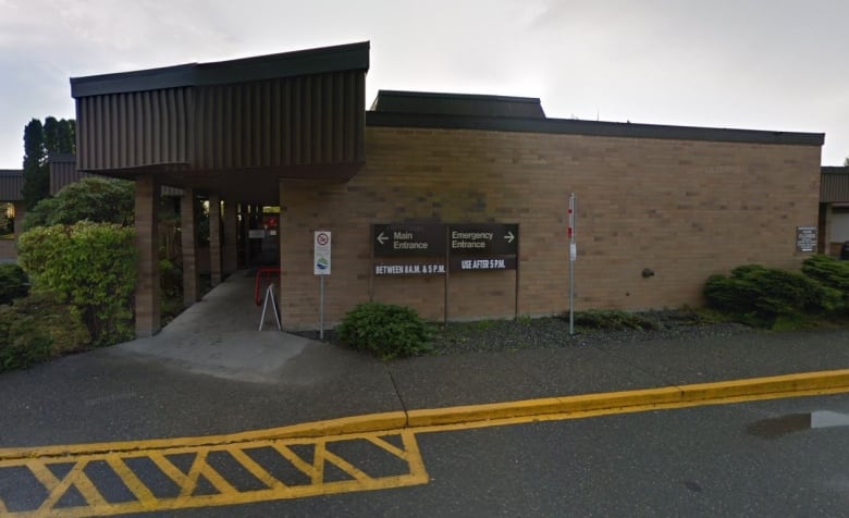 A one-storey brick building with two signs. One reads Main Entrance, and the other reads Emergency Services. 