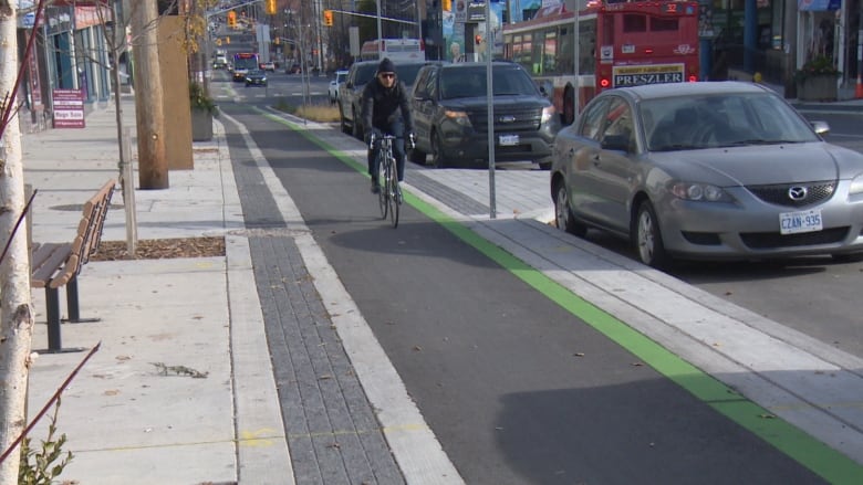 A cyclist rides along a bike lane on Toronto's Eglinton Avenue in November 2023.